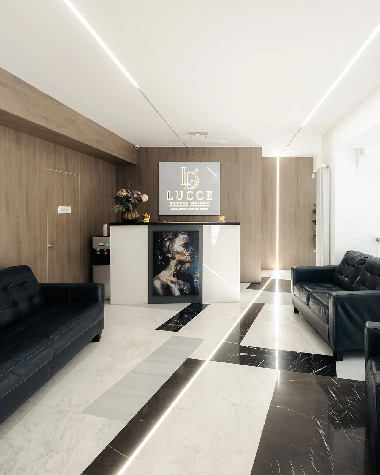Recepția clinicii stomatologice Lucce Dental Maison din București, cu logo-ul luminos pe perete de lemn